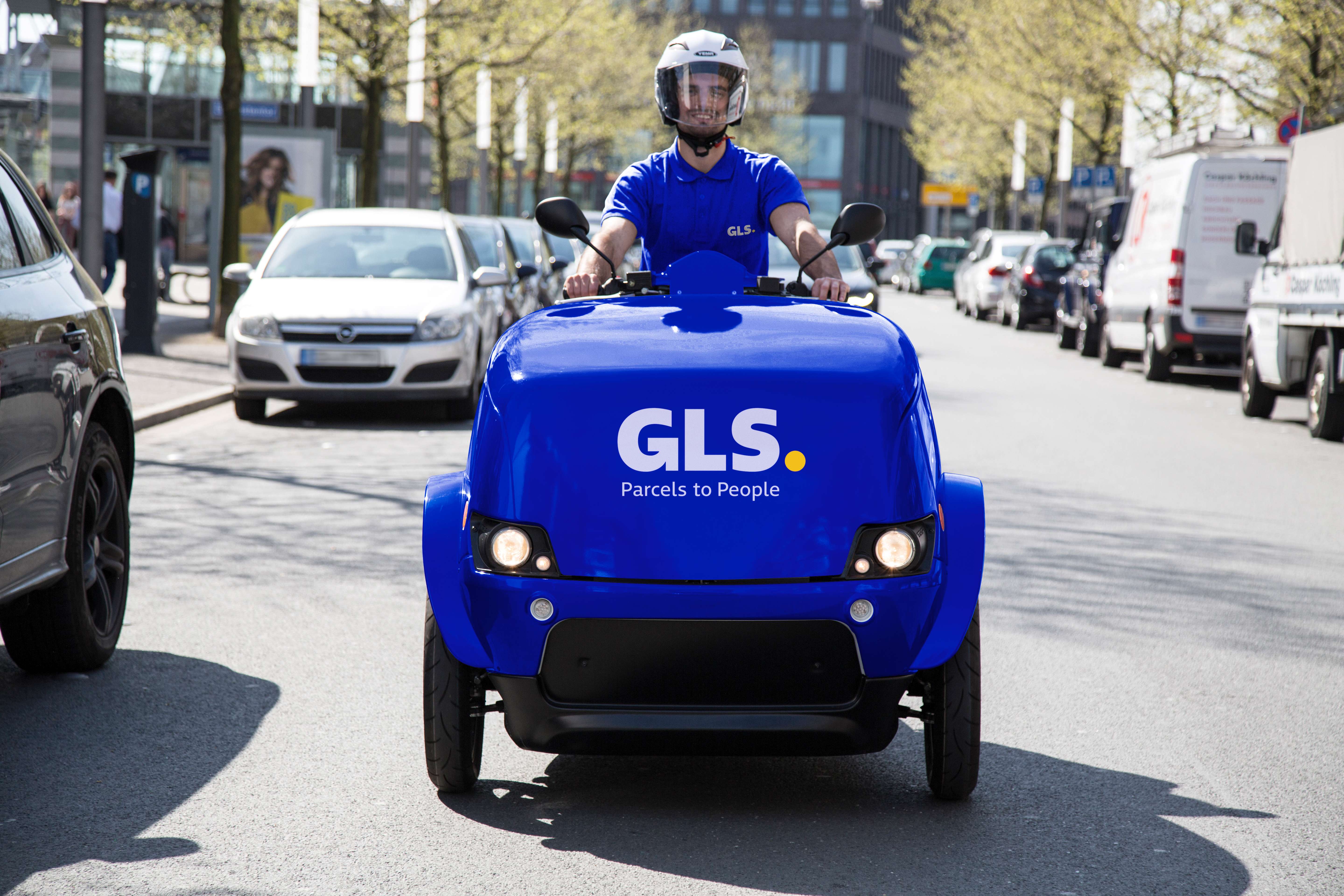 Ein junger GLS-Mitarbeiter auf einem GLS escooter